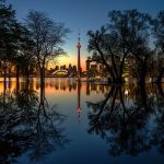 Floodwaters reflect trees and the Toronto skyline after sunset, Olympic Island, Toronto Islands