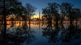 Floodwaters reflect trees and the Toronto skyline after sunset, Olympic Island, Toronto Islands